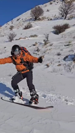 Diş hekimi tırmandığı dağdan snowboard yaparak indi